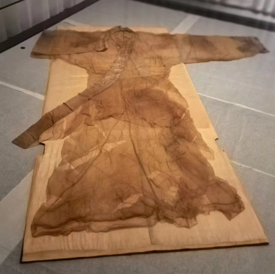 这件曲裾式素纱单衣交领右衽,衣料为轻薄,没有染色的平纹方孔丝织物