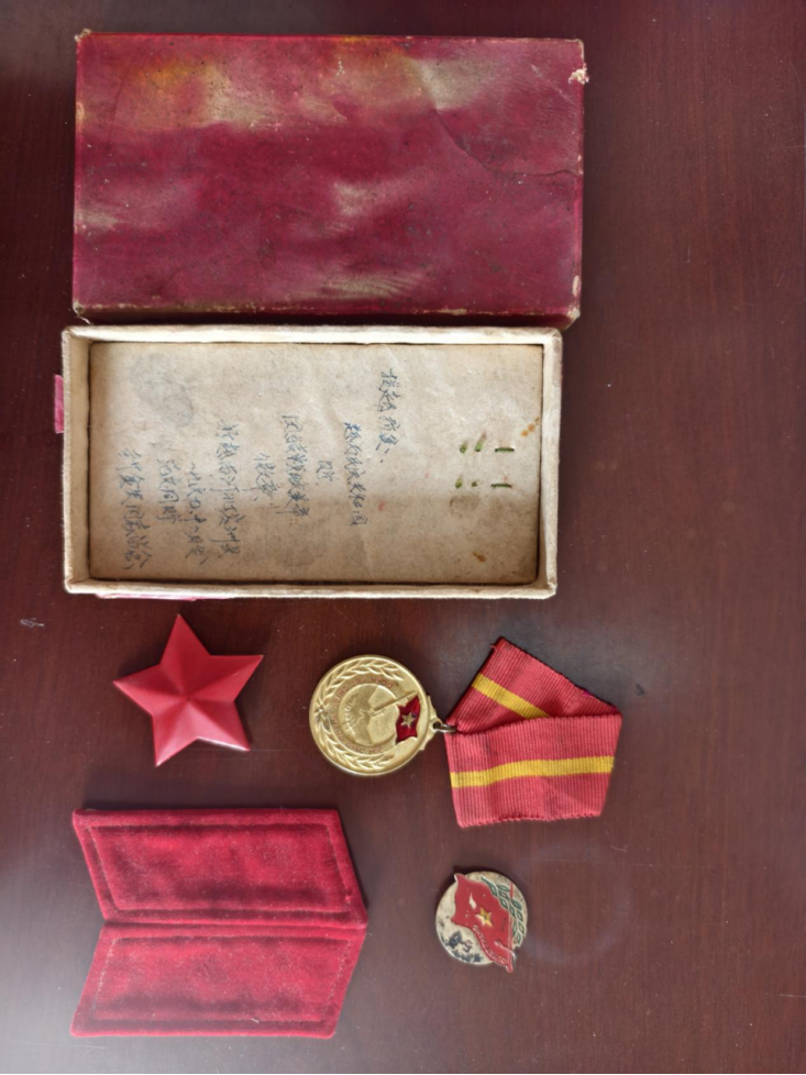 老兵封金生小心翼翼揭开一层层包裹,里面是一枚近乎崭新的援越抗美