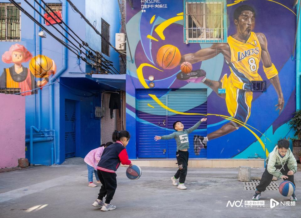 一市民途经墙绘《执着·信念》.兴塘广场篮球场.