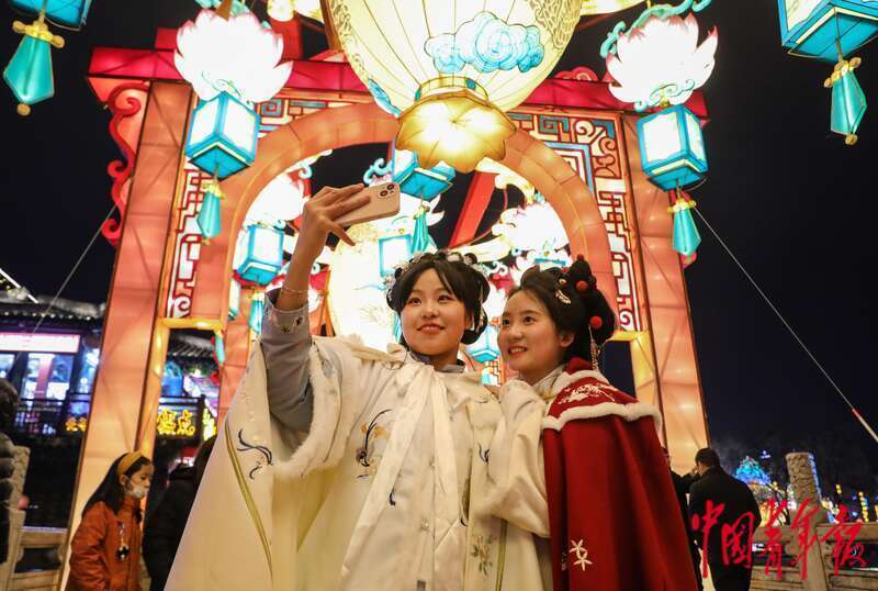 夫子庙景区,来自山东青岛的大二学生贾玉铭(右)和刘梦娇在灯彩下自拍