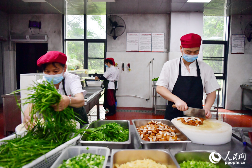 红谷滩区九龙馨苑社区的幸福食堂后厨,工作人员正将做好的菜品装盘