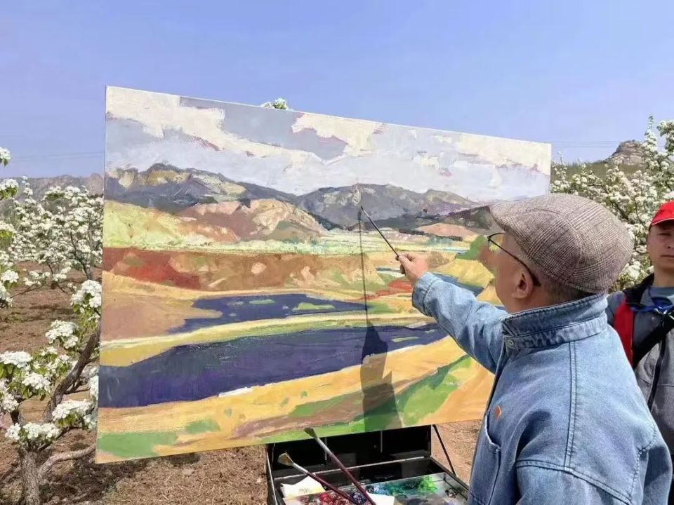 盘锦市有一支由34人组成的游学团在村里参观,被画家绘画的场面吸引.