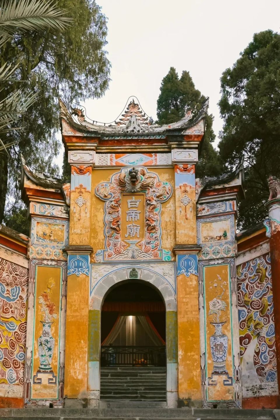 后沿步道上山,行至装饰着繁复彩绘灰塑的白帝城大门,可远望长江与夔门