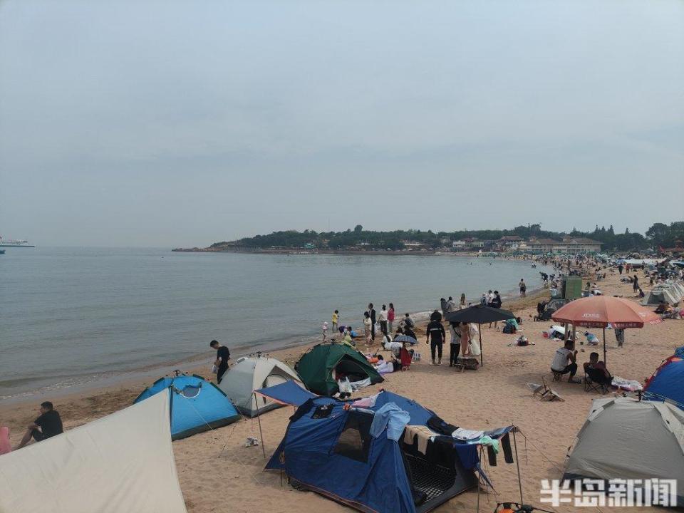 海水浴场,大量市民游客在此玩水,扒沙,晒日光浴……许多小朋友在沙滩