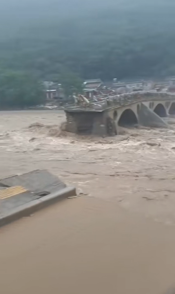 宝鸡渭滨洪水漫堤百米大桥被冲断,有人从齐腰深水中救出落水者,消防