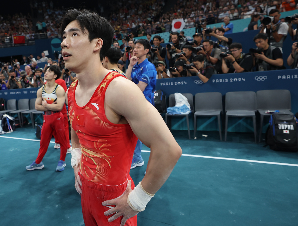 7月31日,中国选手张博恒在单杠比赛后等待成绩