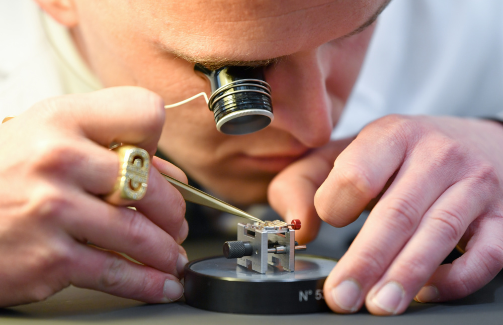 3月27日,在瑞士日内瓦,一名钟表匠在"钟表与奇迹"高级钟表展上展示