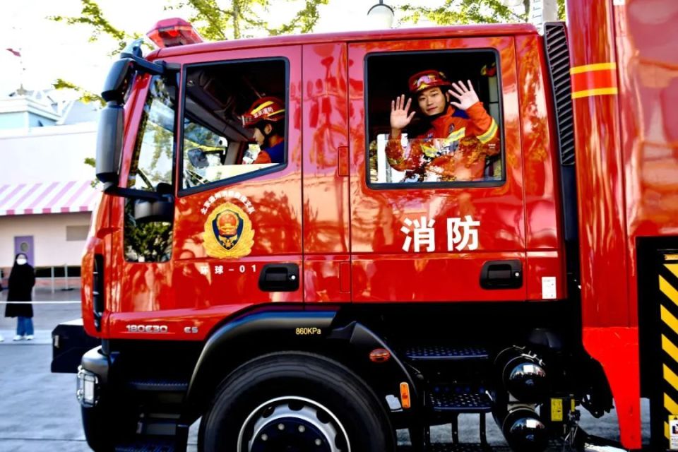一辆抢险救援车和一辆举高平台消防车依次驶来其间的消防员们分别身着