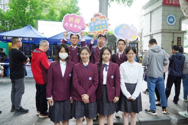 南京市人民中学考点外,南京市第九中学高一学生为高三学子加油助威.