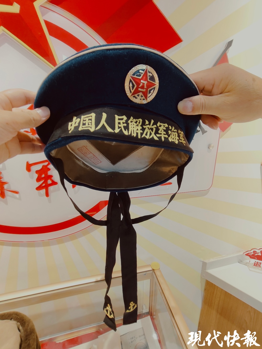 "这是一顶55式军帽,帽徽中间是解放军军徽,红五角星里写有八一,绿