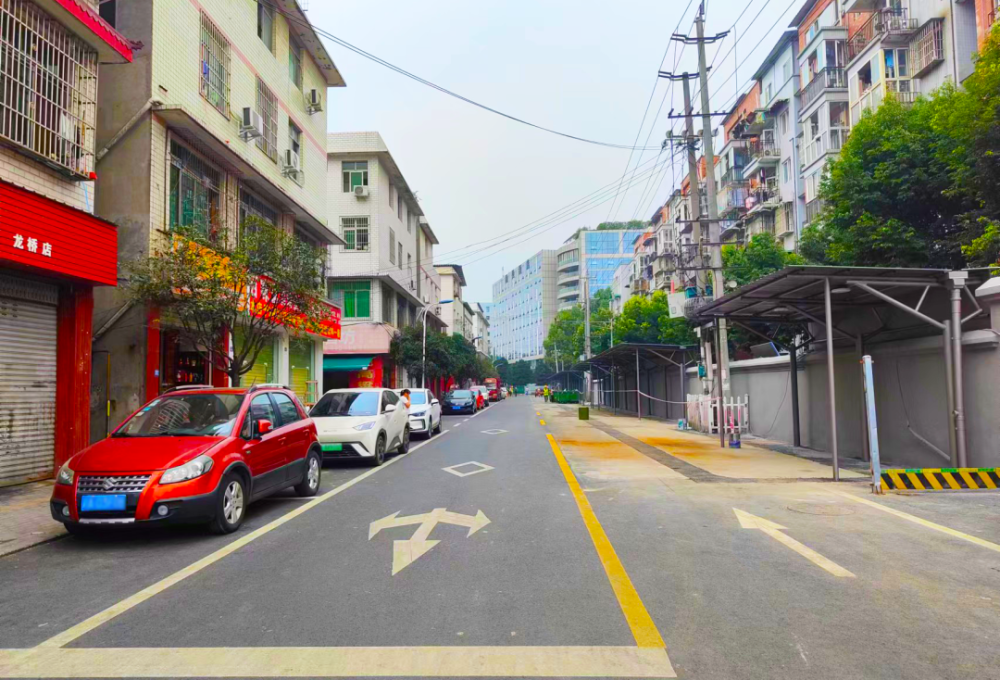 沿街商铺经营井然有序街边汽车停放有序,路面干净整洁行走在龙桥小区"