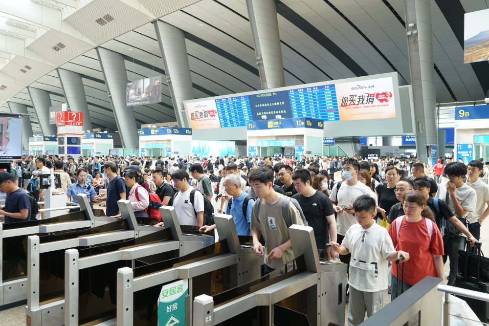 6月8日,北京南站迎来客流高峰,旅客正在排队检票乘车.
