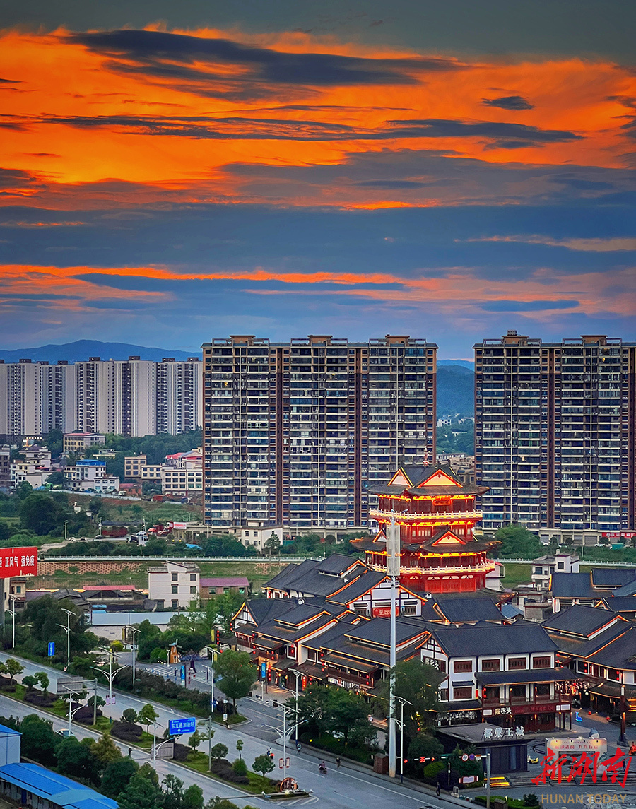 6月11日傍晚,武冈市都梁王城仿古建筑群灯火阑珊,和晚霞交相辉映,美不
