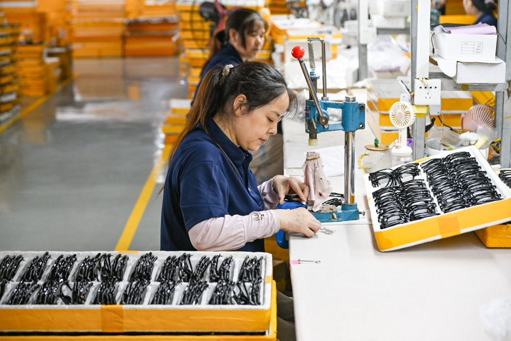 6月10日,重庆市奉节县生态工业园区一眼镜生产企业工人在生产车间作业
