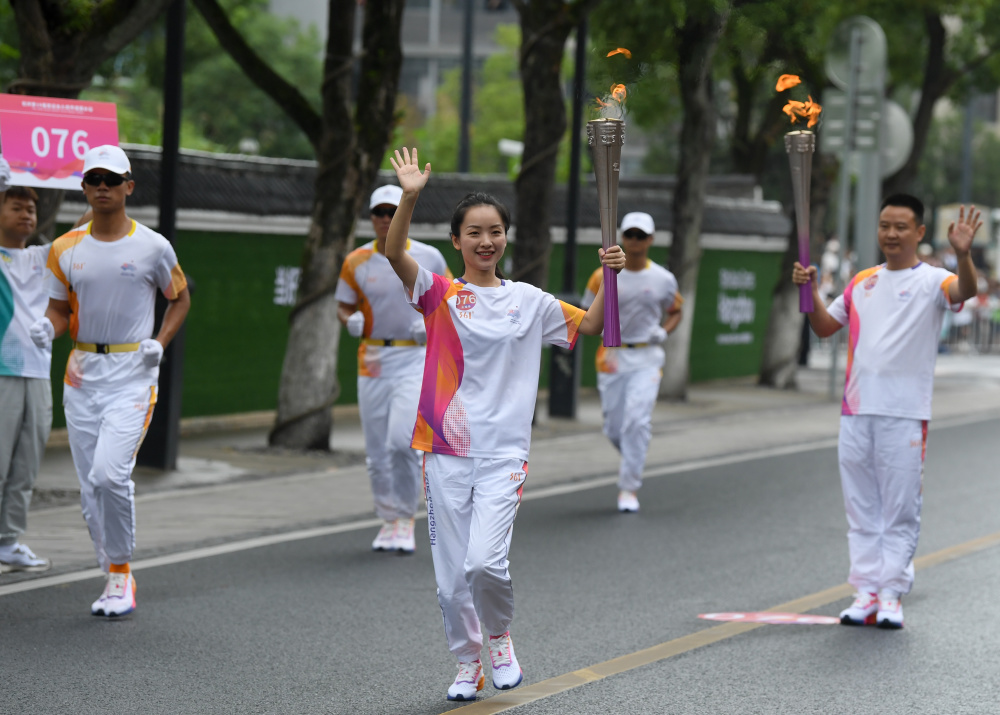 新华社记者 翁忻旸 摄9月16日,身着民族服饰的演员在火炬传递沿线表演