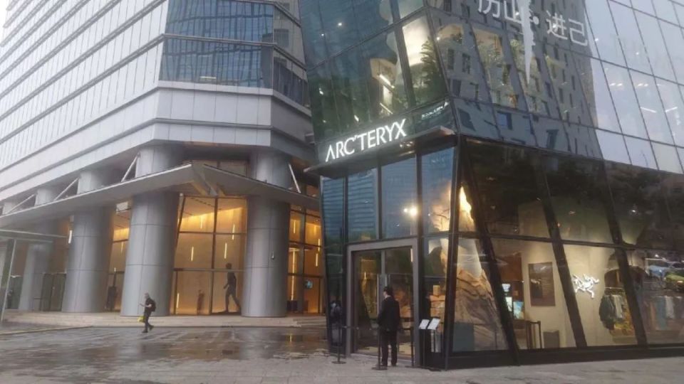 身着西装的店员在始祖鸟店铺门口拉起了一米线亚玛芬体育2023年全年