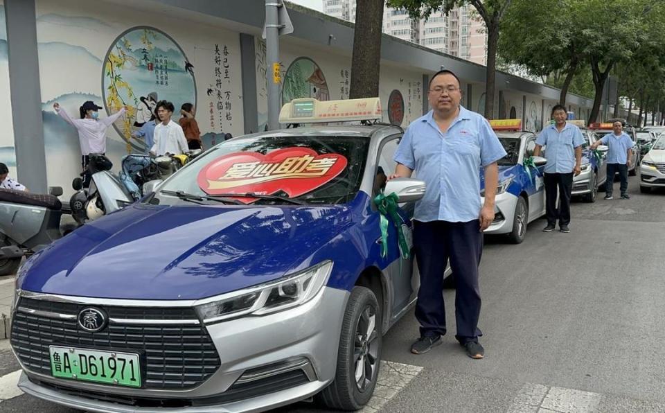 在济钢高中门口,整洁划一的出租车停放在路边,送考司机们整装待发.