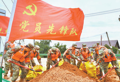 老柱村,党员志愿者李宗明(左后)在洪水中驾驶救援艇紧急转移被困群众