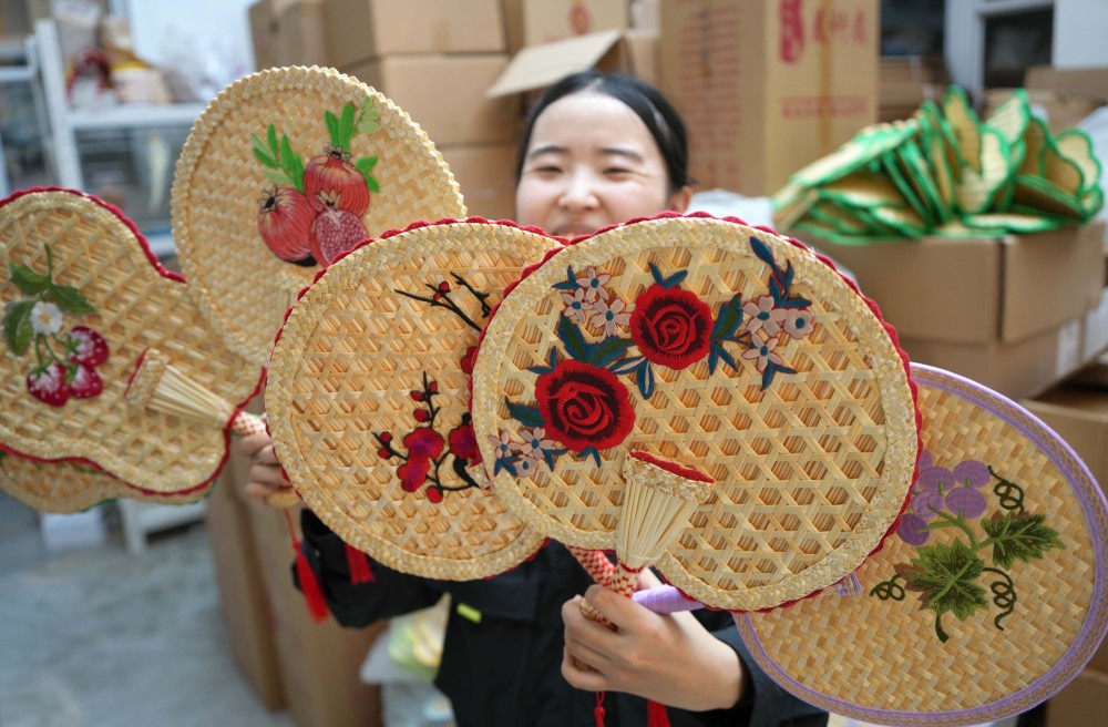 8月14日,山东省新泰市羊流镇的农户在制作麦秆扇.