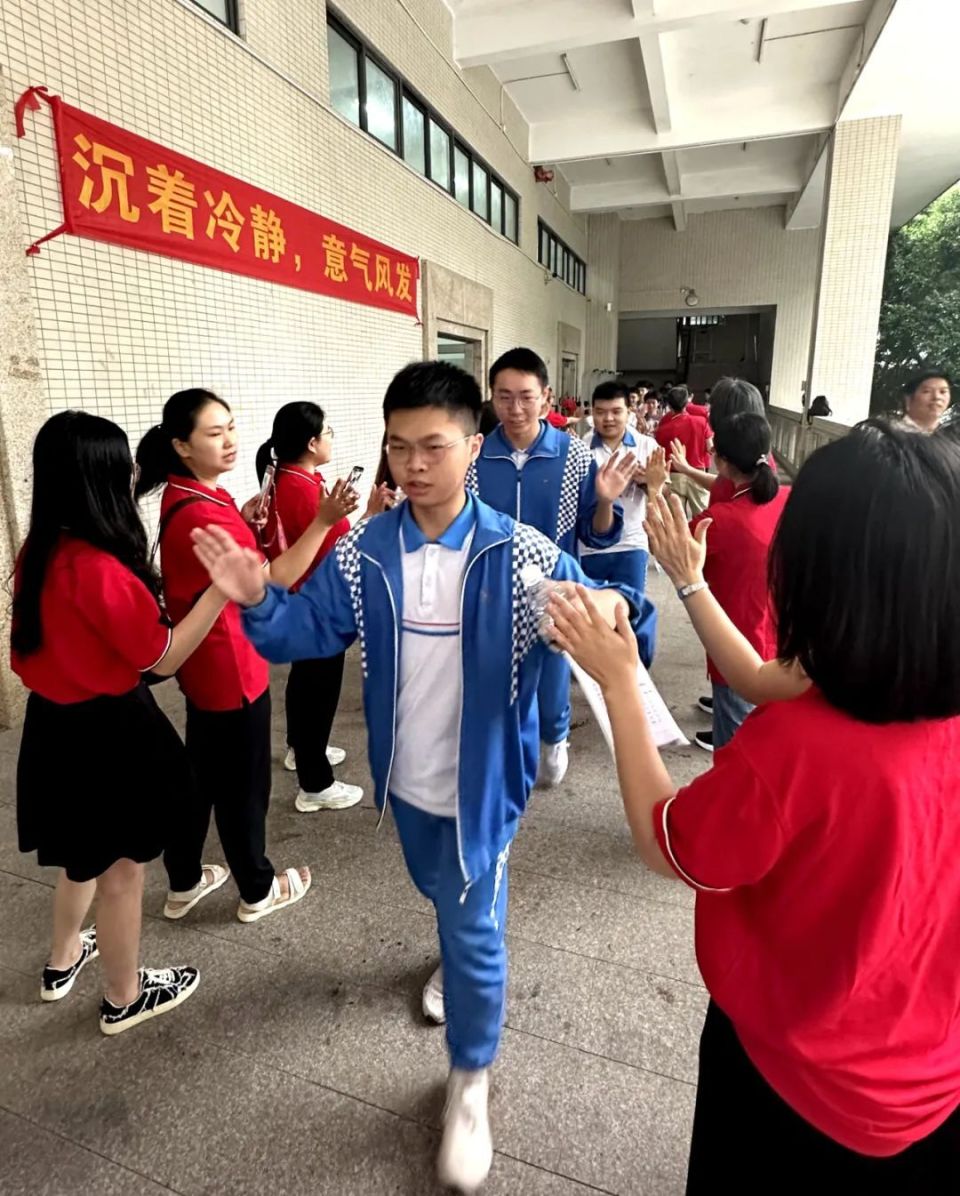 在新华中学考点,身着红色"战衣"的老师们,将象征着幸运和喜悦的糖果