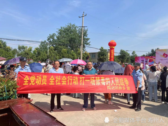 工作人员和派出所干警拉起横幅,摆放展板,发放禁毒,反邪教宣传手册,向