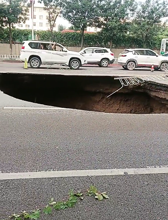 甘肃庆阳一路面塌陷出深坑,多方回应:暴雨所致,现场道路已封闭