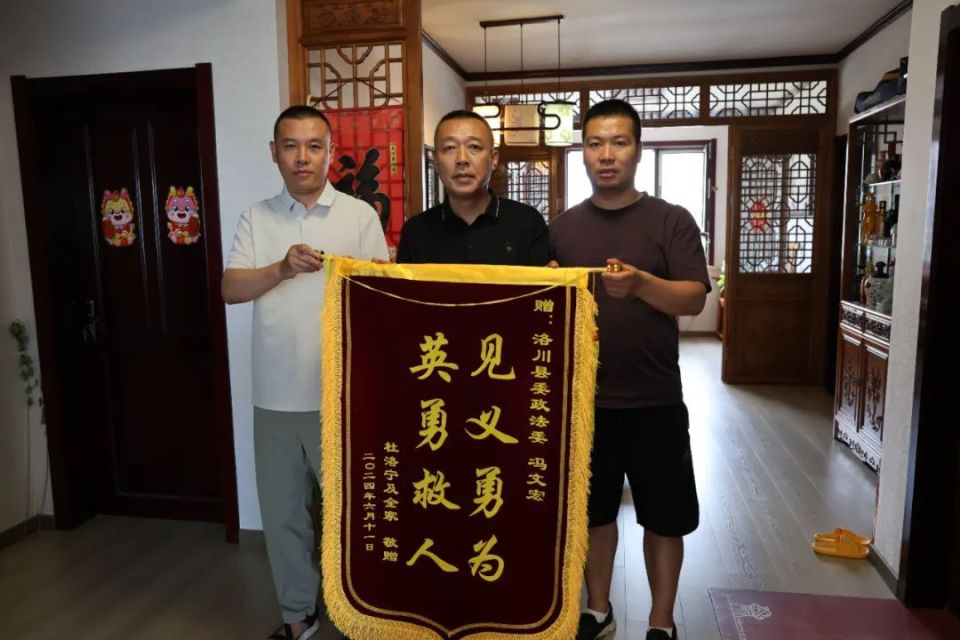 "6月11日,洛川县龙翔苑小区居民杜洛宁将一面写着"见义勇为 英勇救人"