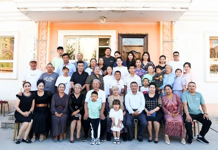 在位于新疆青河县的家中,阿尼帕(前排右五)和家人一起拍摄全家福