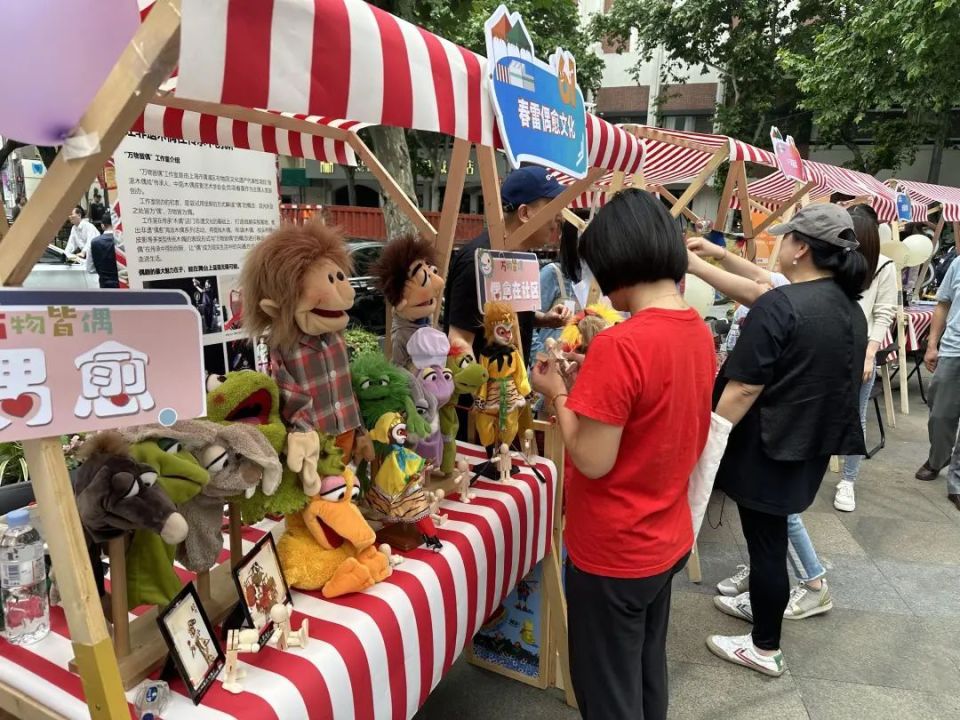 在市集现场,爱心摊位一字排开,摆满了各种书籍,文具,玩具和手工艺品等