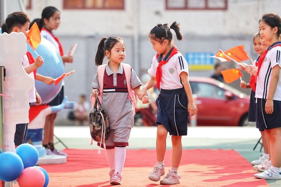 开学首日,小学生手牵手踏上红毯,用太空植物妆点校园,听民警上开学第
