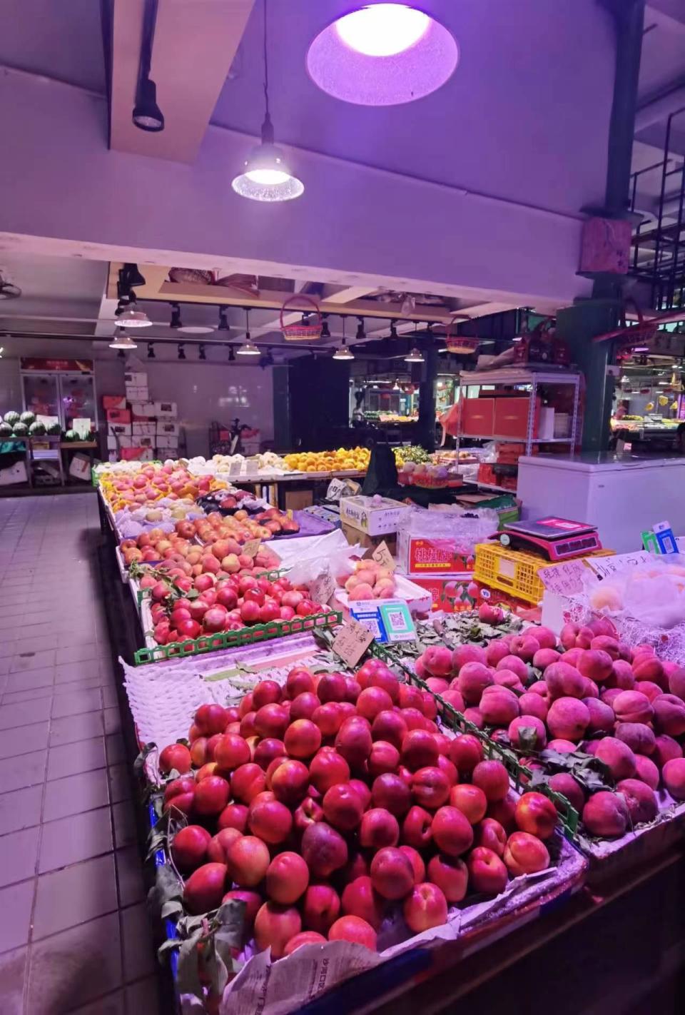 在天河区的石溪肉菜市场外的一家水果店,记者发现店内使用有色光源