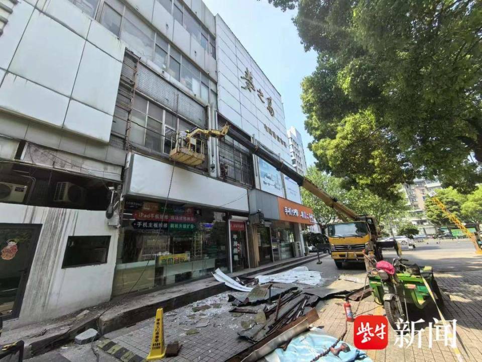 地面上竖着"高空作业,危险勿近"的牌子,现场拉起警戒线,梁溪城管惠山