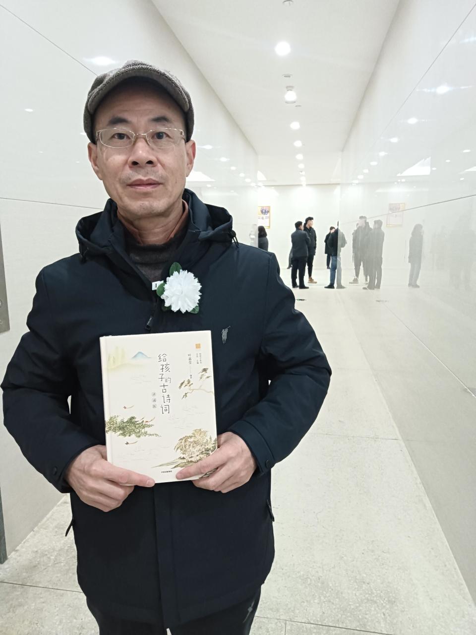 告别厅外，来自安徽的李世源先生展示新买的叶先生著作。庞永力摄