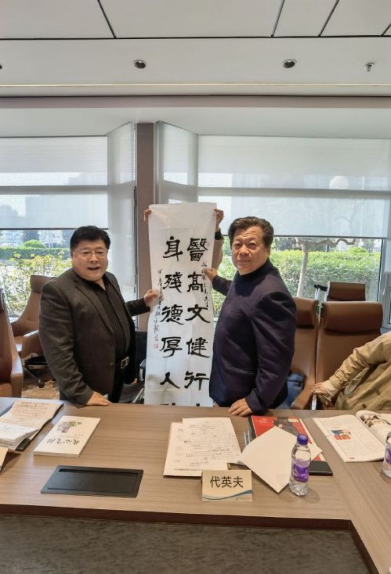 赵立志(左)和代英夫展示书法家封官龙赠与的墨宝:医高文健行远,身残德