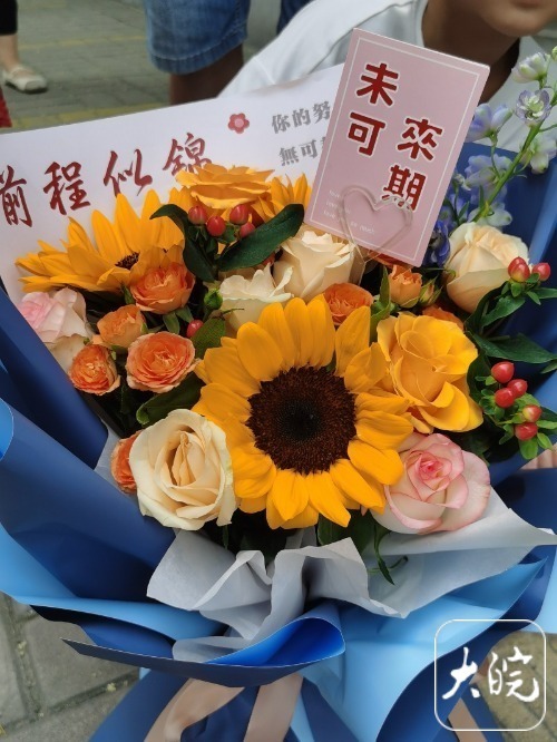 翘首以盼的目光,高举寓意"一举夺魁"的向日葵花束,手捧酸奶组成的花束