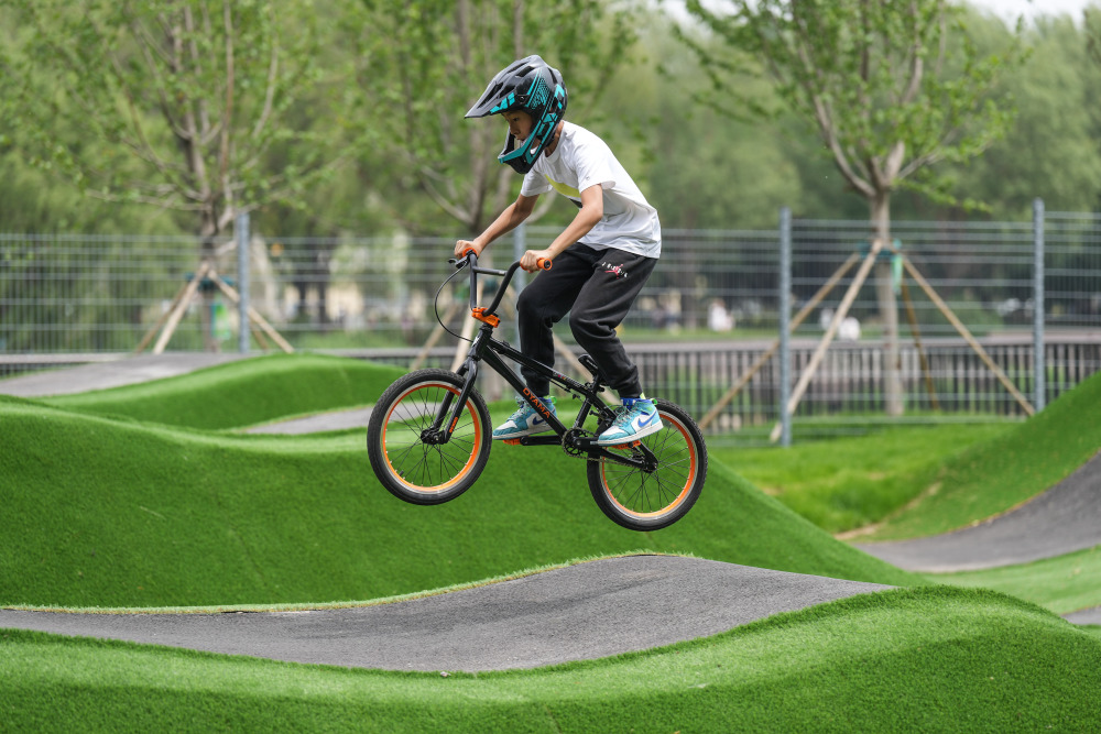 5月27日,一个小朋友在沈阳国际泵道公园内的泵道骑行.