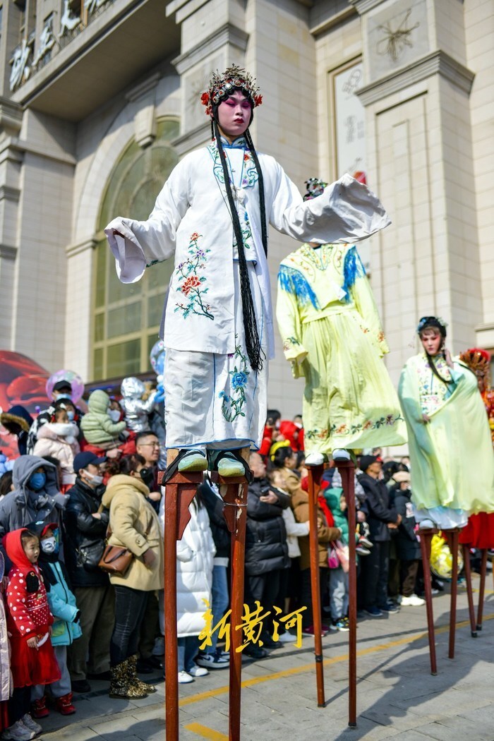 2月10日,在济南阳光新路一商场门前,一场高跷表演烘托出浓浓的节日