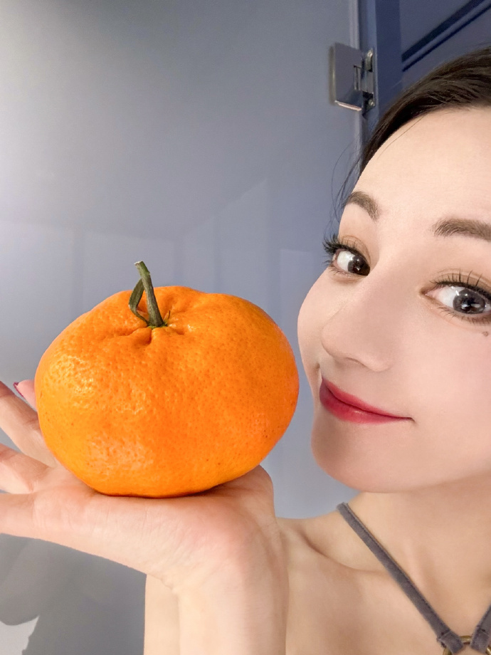 迪丽热巴公开行程受期待手捧金桔显喜庆嘟嘴卖萌宛如少女