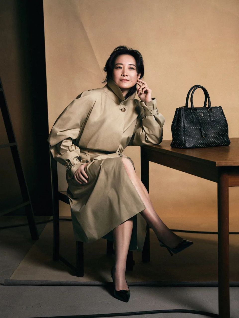 从代言大片里看,贾玲身穿品牌的米色风衣和黑色v领长裙,搭配标志性的