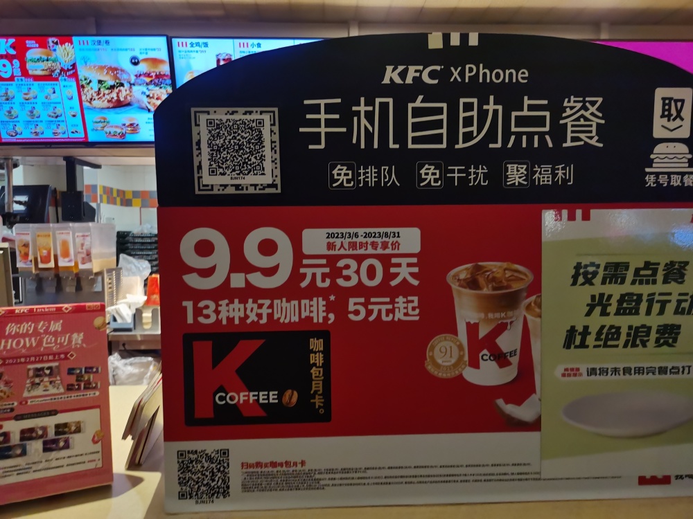 柜台前醒目位置处贴出的"手机自助点餐"二维码,扫描后会弹出肯德基app