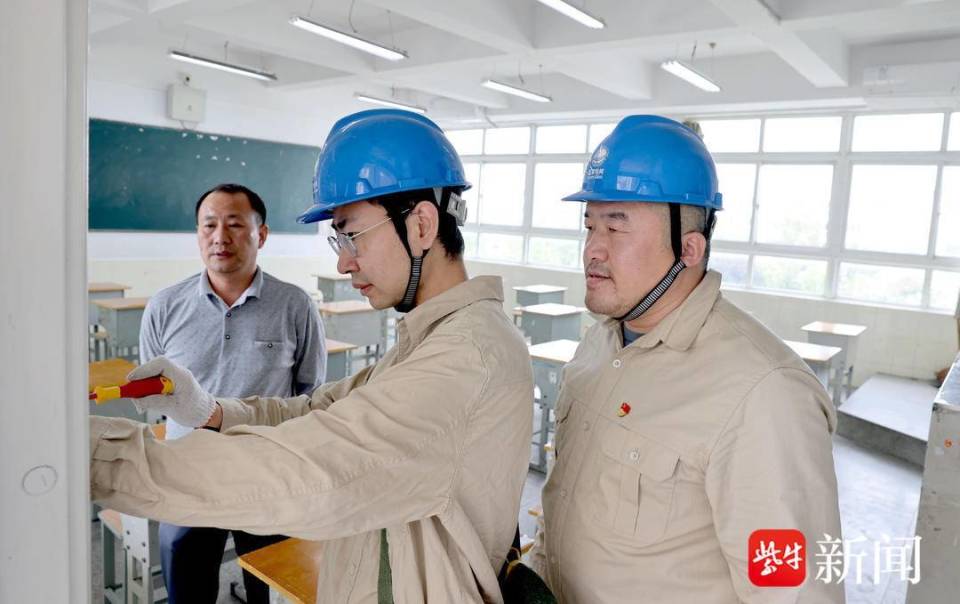 图为6月6日,该公司工作人员来到江都区仙城中学考点检查教室空气开关