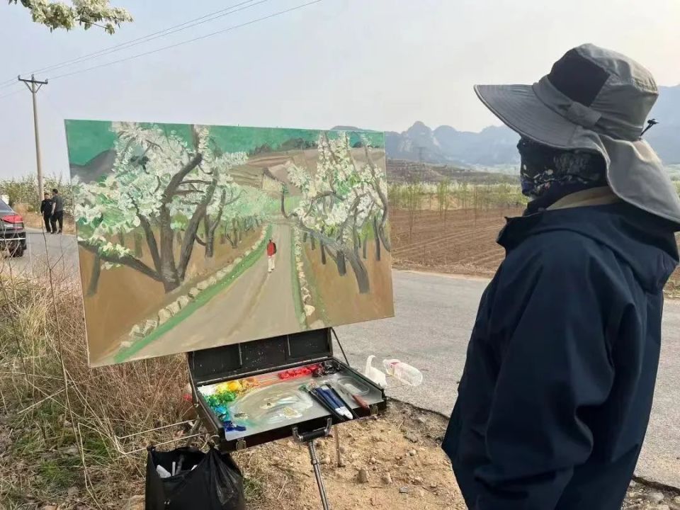 盘锦市有一支由34人组成的游学团在村里参观,被画家绘画的场面吸引.