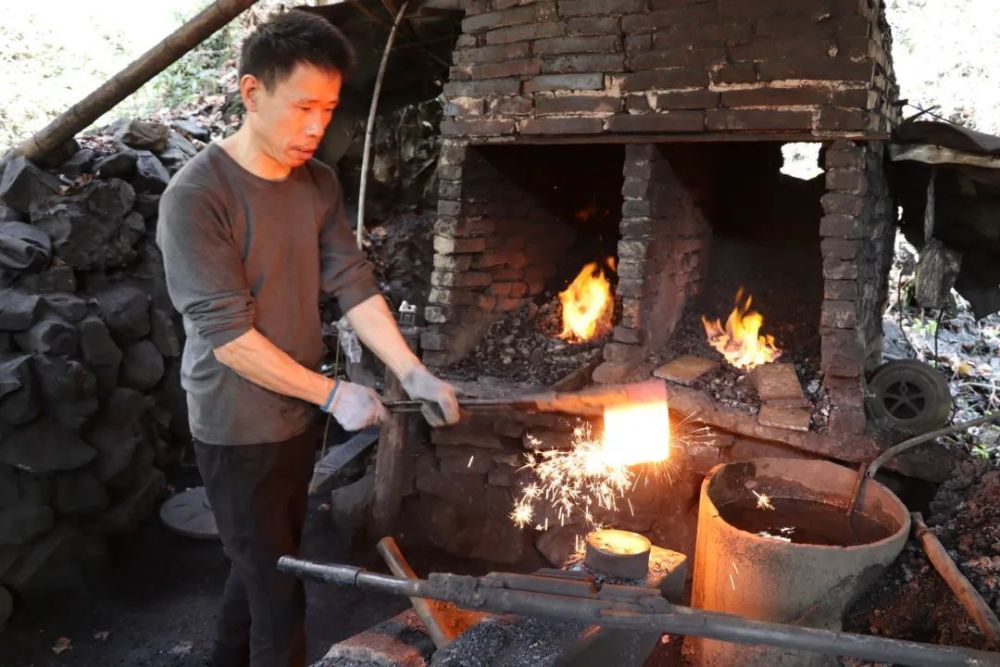 村长边拿着地上的料铁边跟我介绍,打铁器既是个技术活,又是个力气活.