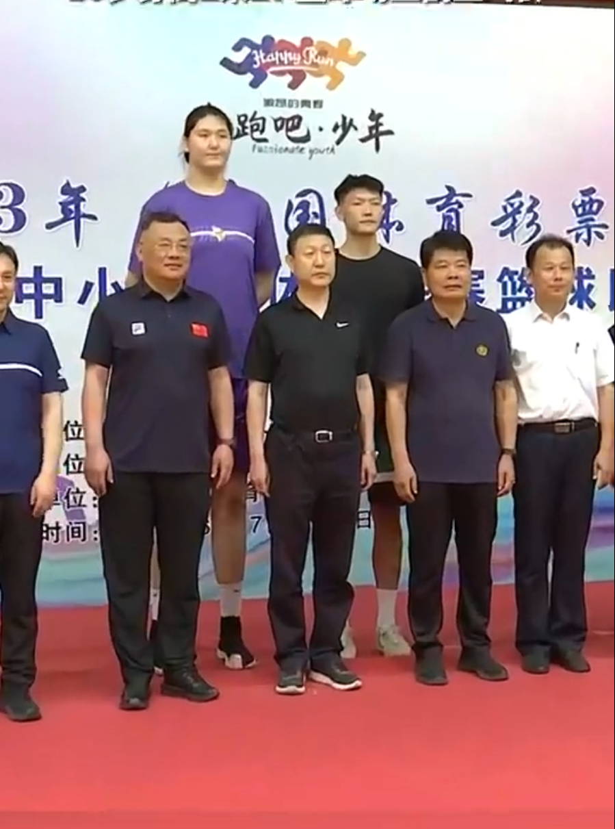 身高2米27的张子宇,即便是站在后排,也比前排的领导们高出来一大截.