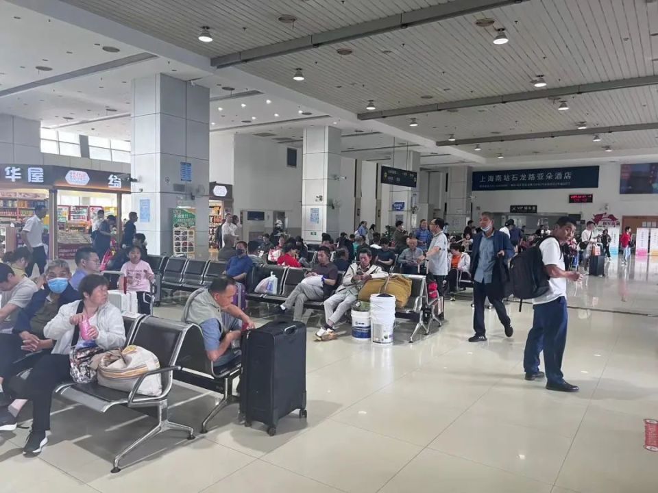 候车大厅里,手提着行李的旅客有序候车.