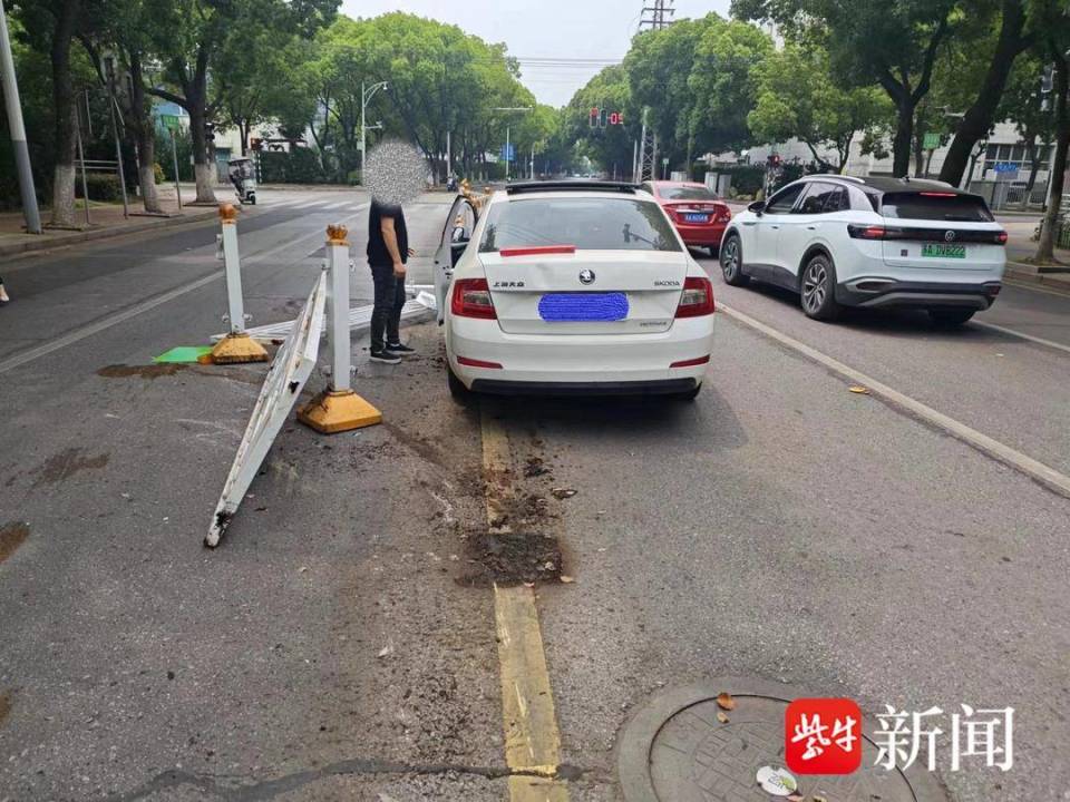 边开车边看手机,小轿车撞倒一大片护栏