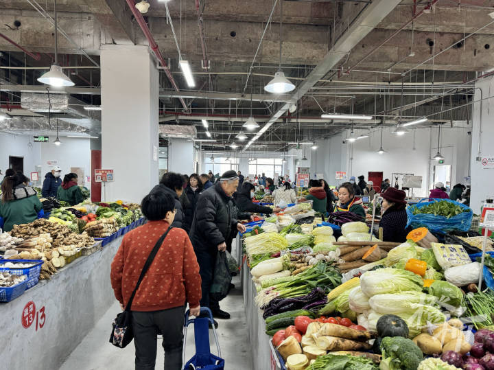 傍晚,农贸市场里来了几位年轻人,胡世龙和女朋友在一个蔬菜摊前停下.