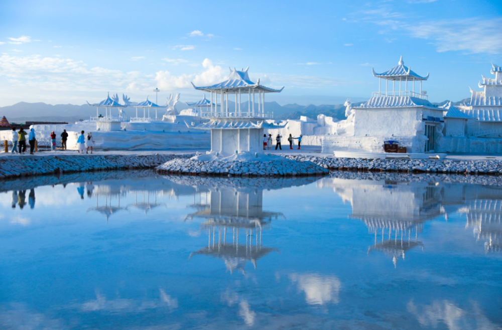 雪山草地间,盐湖水域宽广,银波粼粼,蓝天白云,雪山映入湖中,如诗如画