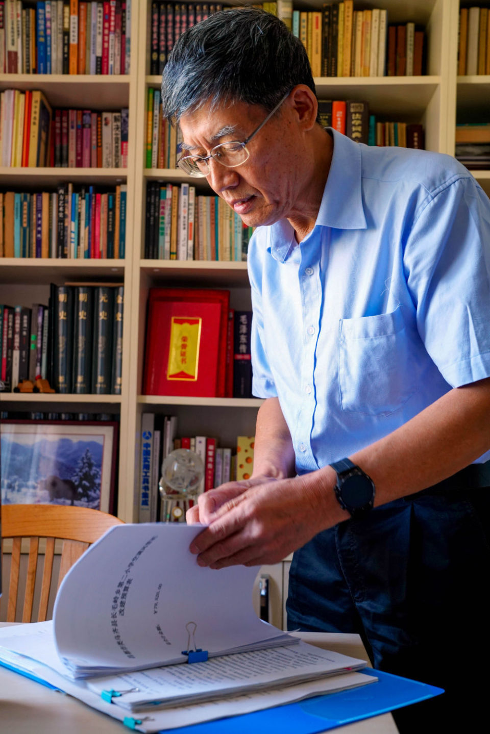 4月28日,李纯民在天津家中整理助学材料.