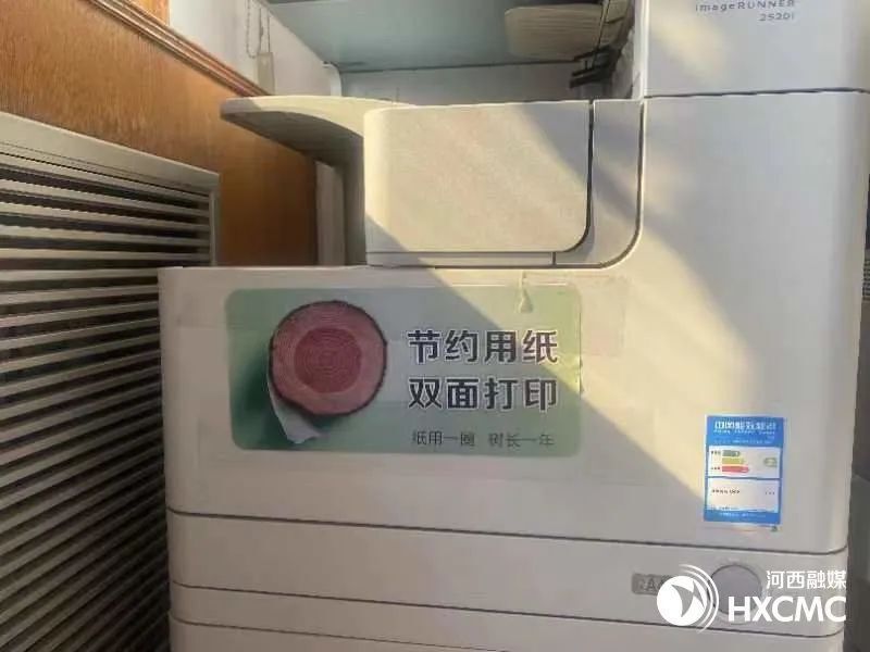 办公设备上,卫生间水龙头旁醒目张贴着"节约用纸 双面打印""节约用水